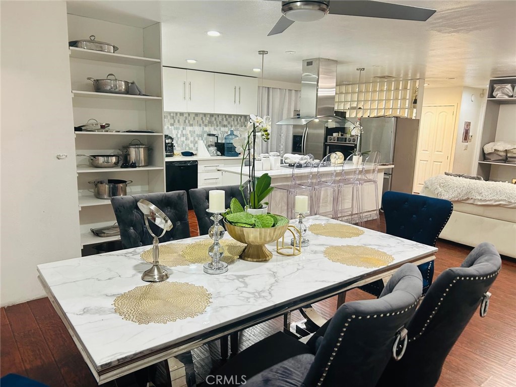 1025 South Riverside Avenue, Unit 26 Rialto, CA 92376 - Photo 13 of 20 a kitchen with stainless steel appliances kitchen island granite countertop a dining table chairs and a refrigerator