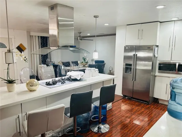 a kitchen with kitchen island a sink stove and refrigerator