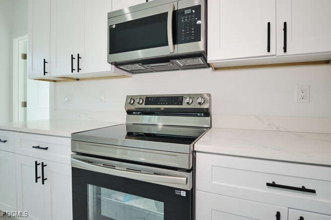 3421 55th Street West Lehigh Acres, FL 33971 - Photo 13 of 38 a stove top oven sitting inside of a kitchen