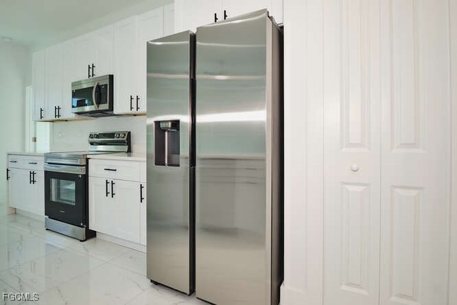 3421 55th Street West Lehigh Acres, FL 33971 - Photo 16 of 38 a metallic refrigerator freezer sitting in a kitchen