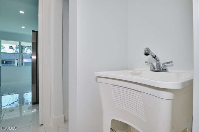 3421 55th Street West Lehigh Acres, FL 33971 - Photo 17 of 38 a bathroom with a sink and a mirror