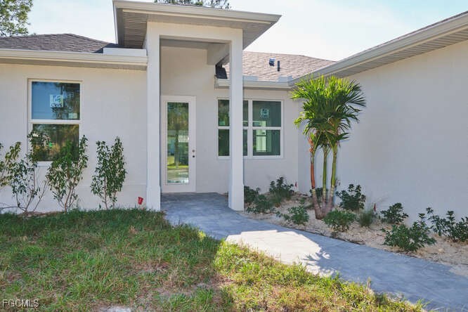 3421 55th Street West Lehigh Acres, FL 33971 - Photo 3 of 38 a front view of a house with garden