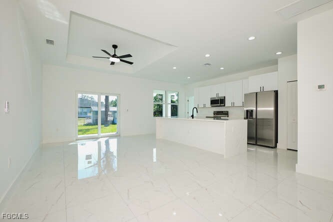 3421 55th Street West Lehigh Acres, FL 33971 - Photo 6 of 38 a living room with stainless steel appliances kitchen island furniture and a fireplace