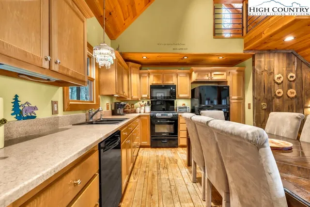 a view of a kitchen with kitchen island stainless steel appliances wooden floor and furniture