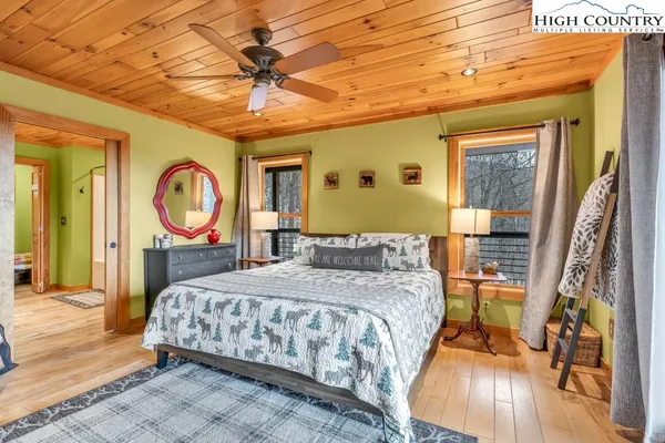 a bedroom with a bed a mirror on dresser and a chandelier