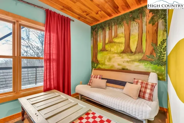 a bedroom with a bed and a flat tv screen on dresser