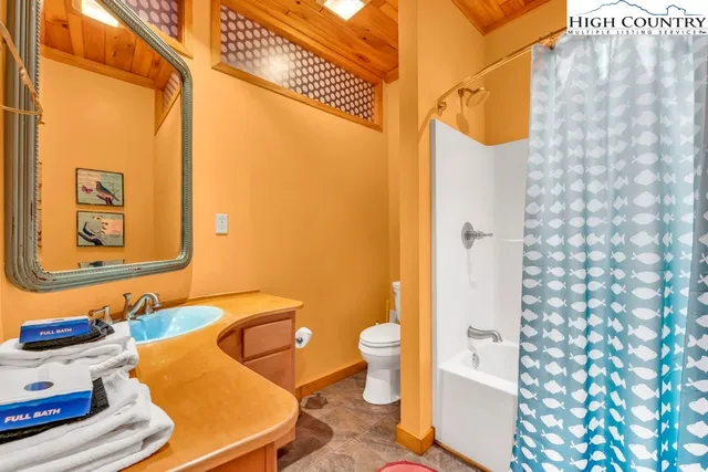 a bedroom with a bed and a lamp on dresser