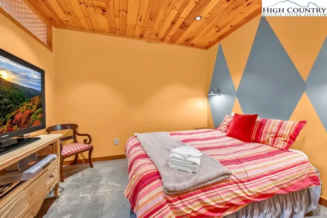 a bedroom with a bed and a large window with the outer view