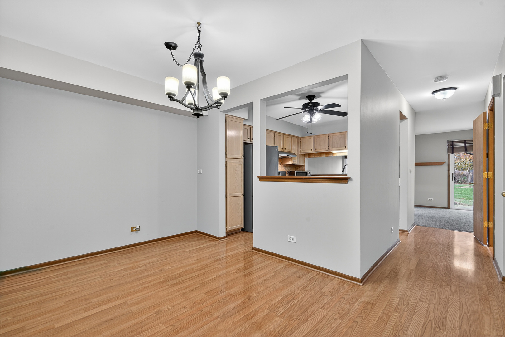 1176 Talbots Lane Elk Grove Village, IL 60007 - Photo 5 of 21 a view of a hallway with wooden floor and a chandelier