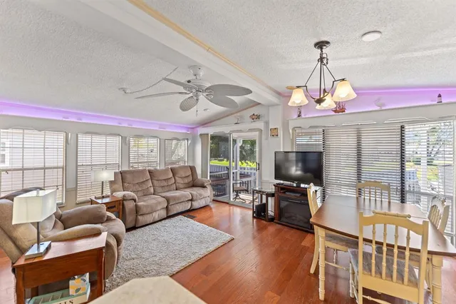 a living room with furniture a flat screen tv and a large window