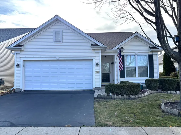 a front view of a house with a yard and potted plants