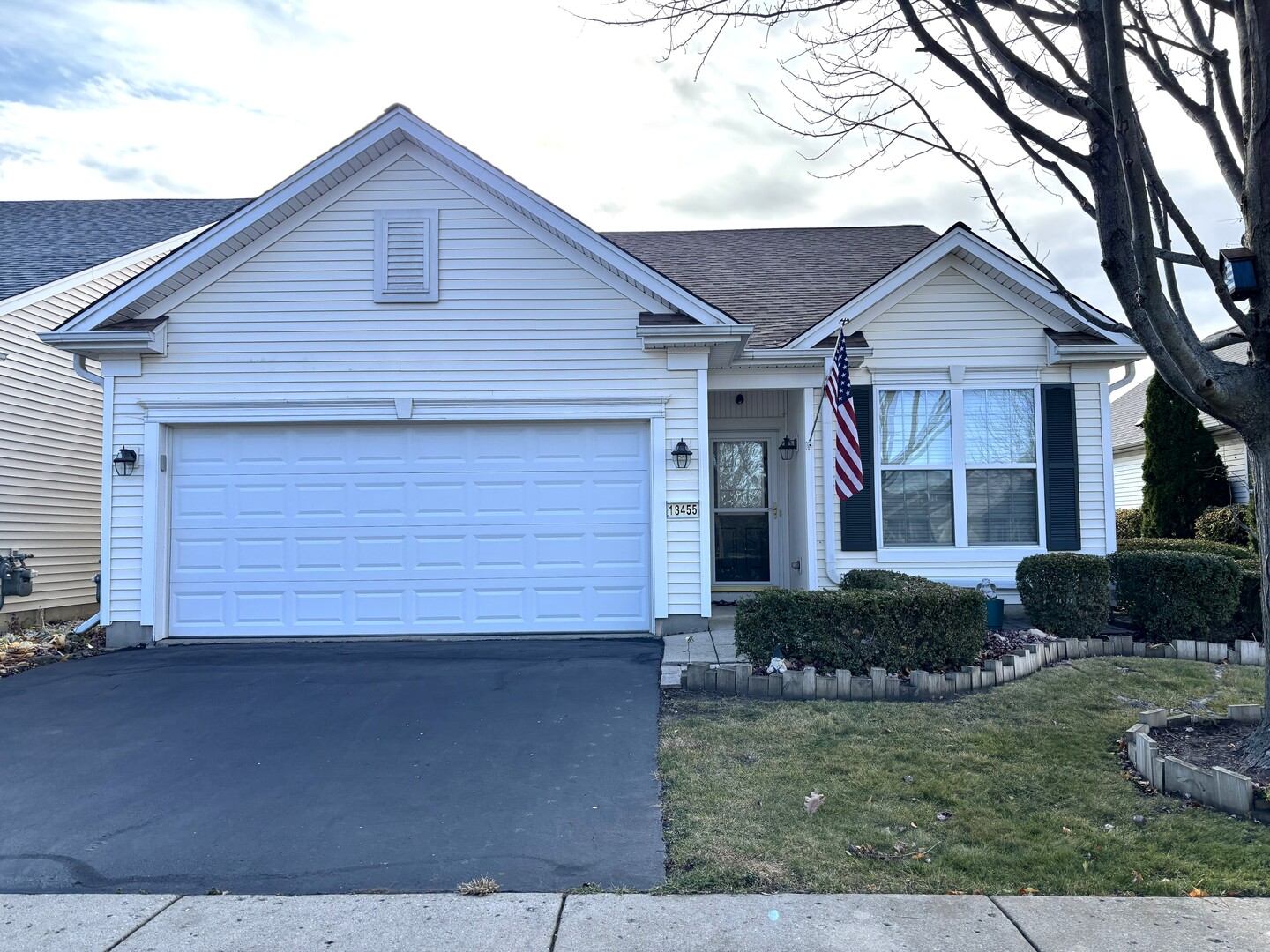 a front view of a house with a yard and potted plants
