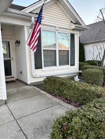 a front view of a house with a yard and potted plants