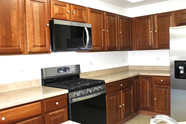 a kitchen with granite countertop a stove and a microwave