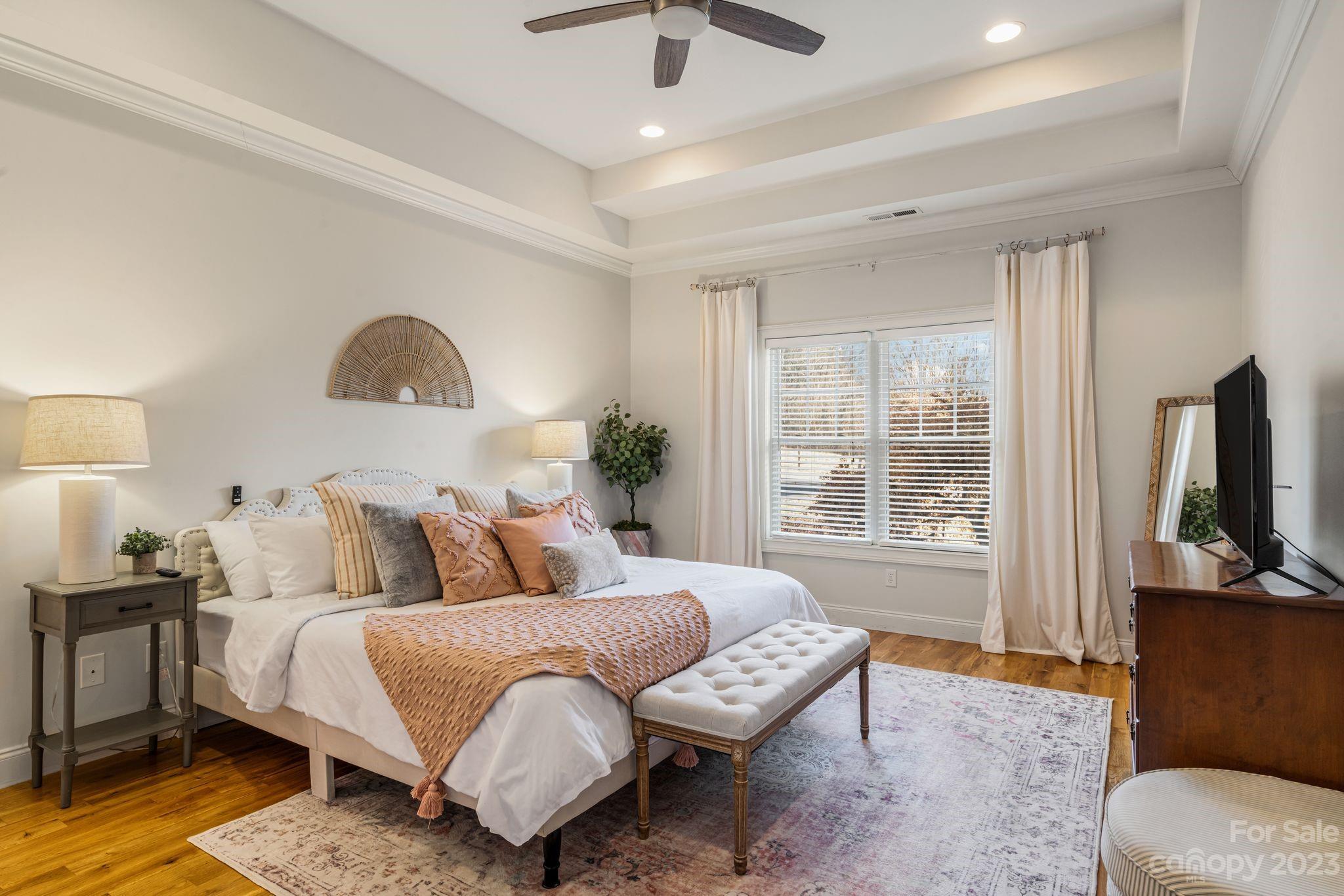 874 Burney Mountain Road Fletcher, NC 28732 - Photo 16 of 37 a bedroom with a bed a couch and a chandelier