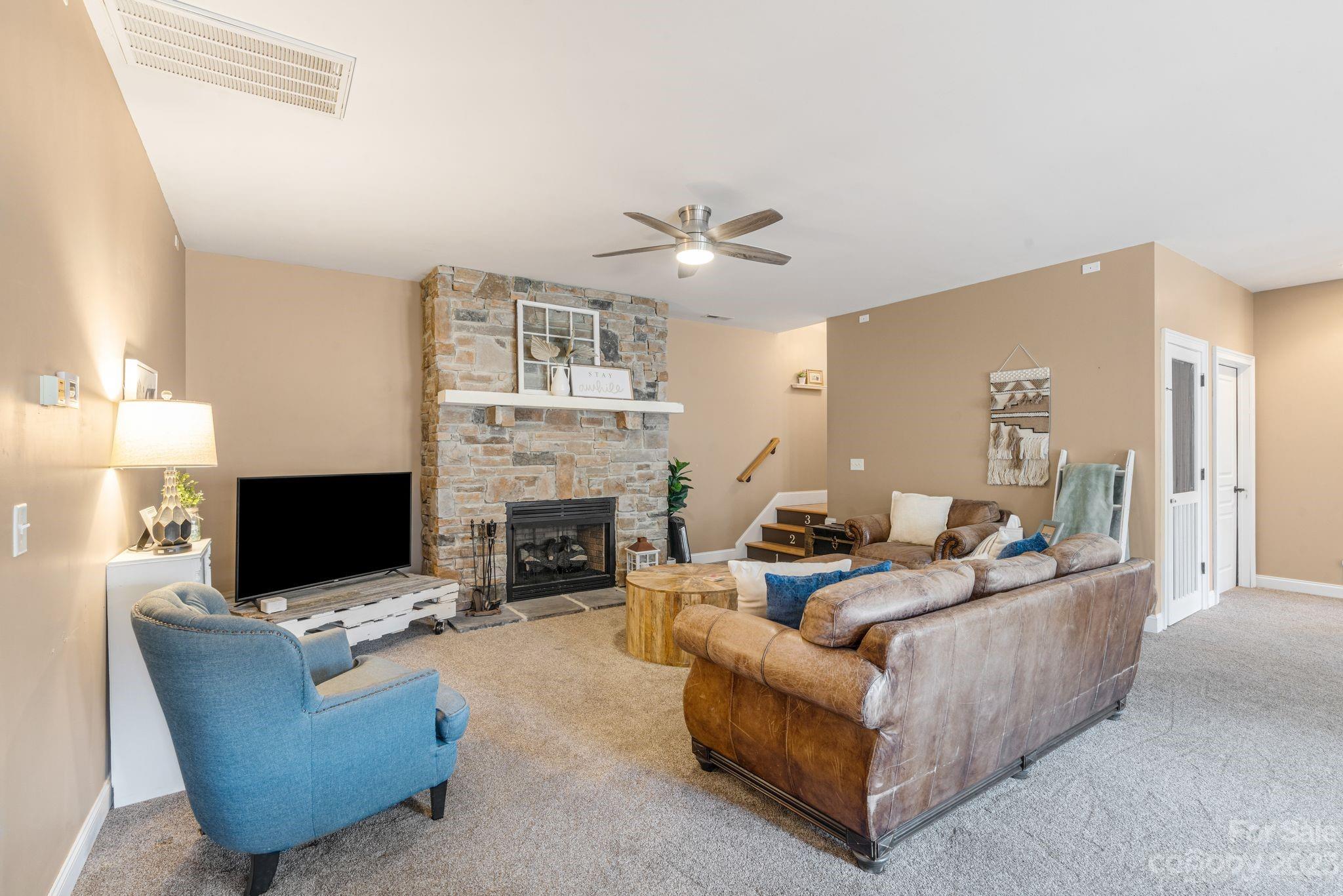 874 Burney Mountain Road Fletcher, NC 28732 - Photo 27 of 37 a living room with furniture a fireplace and a flat screen tv