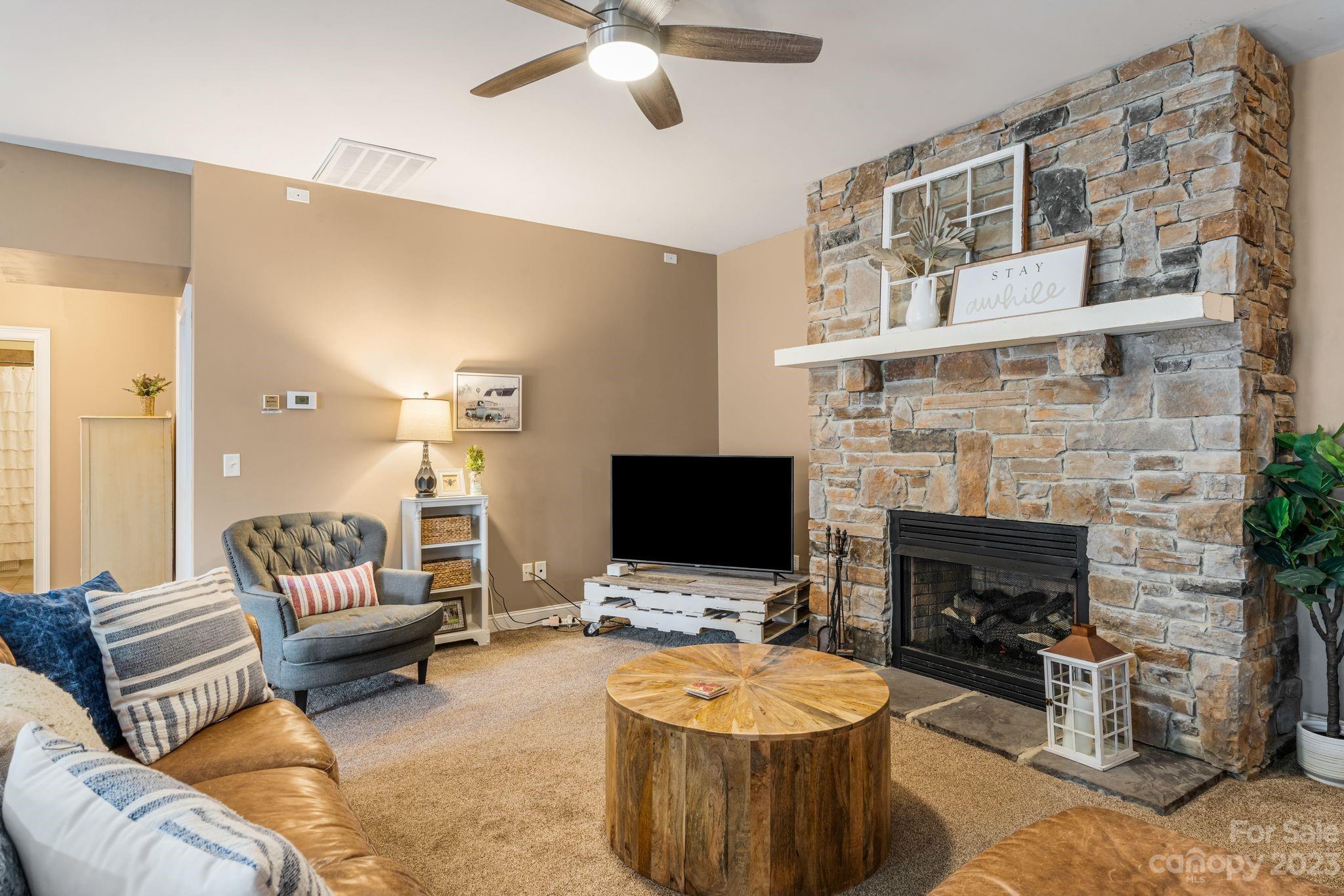 874 Burney Mountain Road Fletcher, NC 28732 - Photo 28 of 37 a living room with furniture a fireplace and a flat screen tv