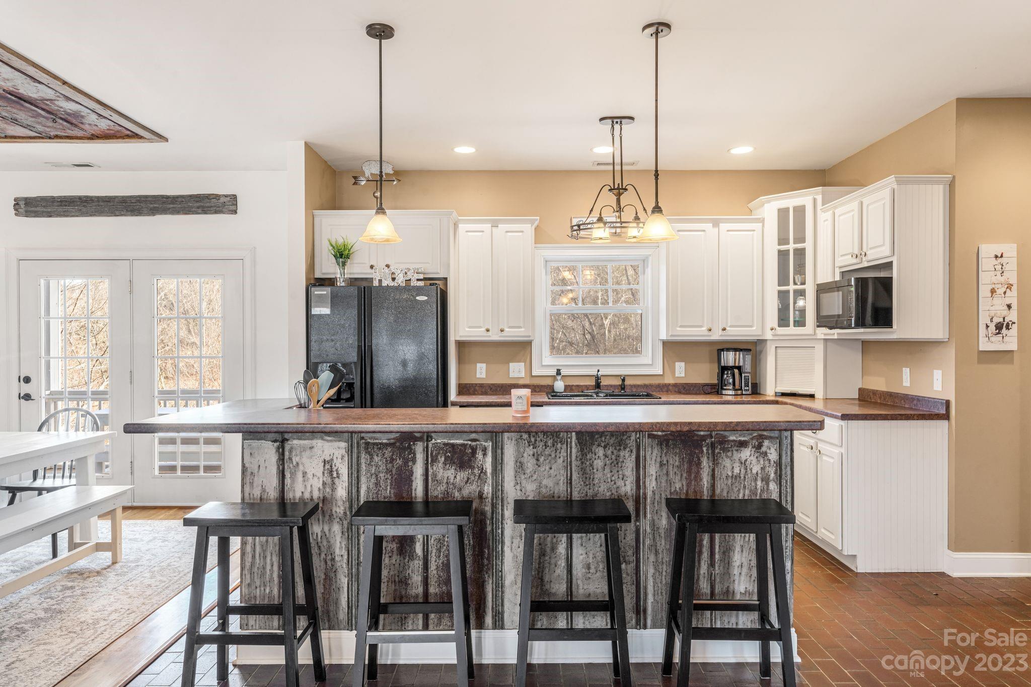 874 Burney Mountain Road Fletcher, NC 28732 - Photo 9 of 37 a large kitchen with granite countertop a table chairs stove and cabinets