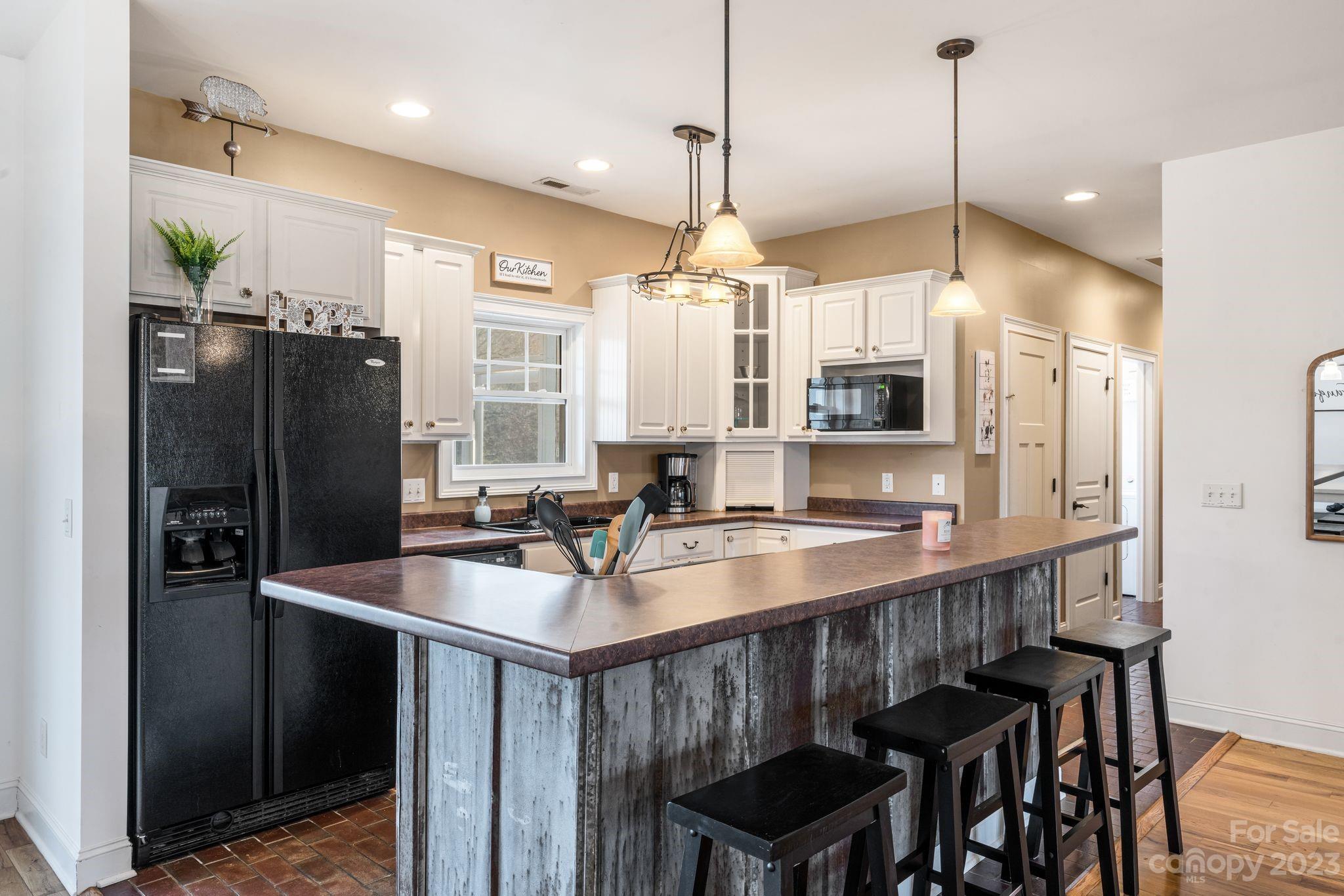 874 Burney Mountain Road Fletcher, NC 28732 - Photo 10 of 37 a kitchen with stainless steel appliances granite countertop a sink a refrigerator a stove a kitchen island with a dining table and chairs