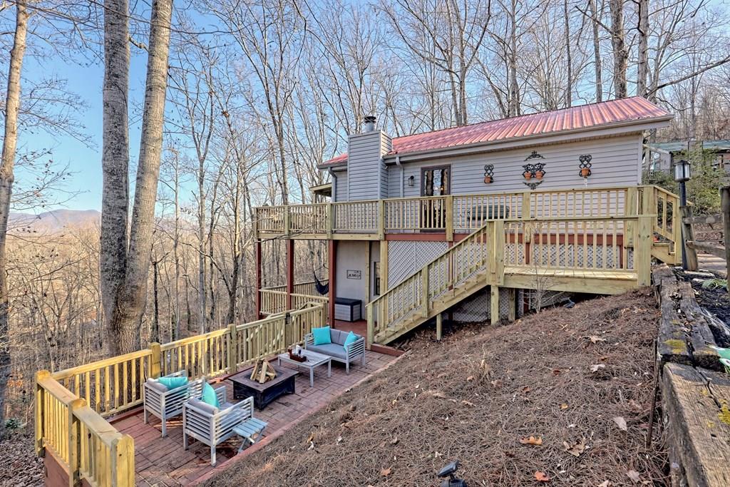 a view of a house with a wooden deck and furniture