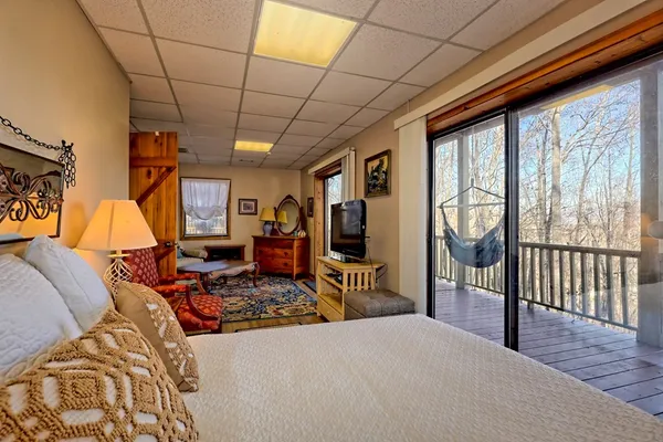 a living room with furniture a flat screen tv and a floor to ceiling window