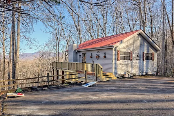 a view of a house with large windows and a table and chairs