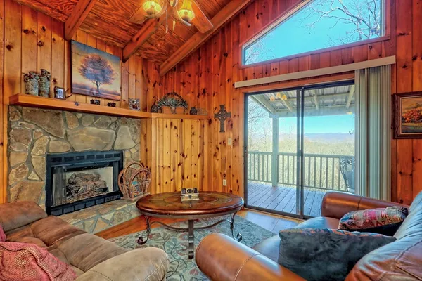 a living room with furniture a fireplace and a floor to ceiling window