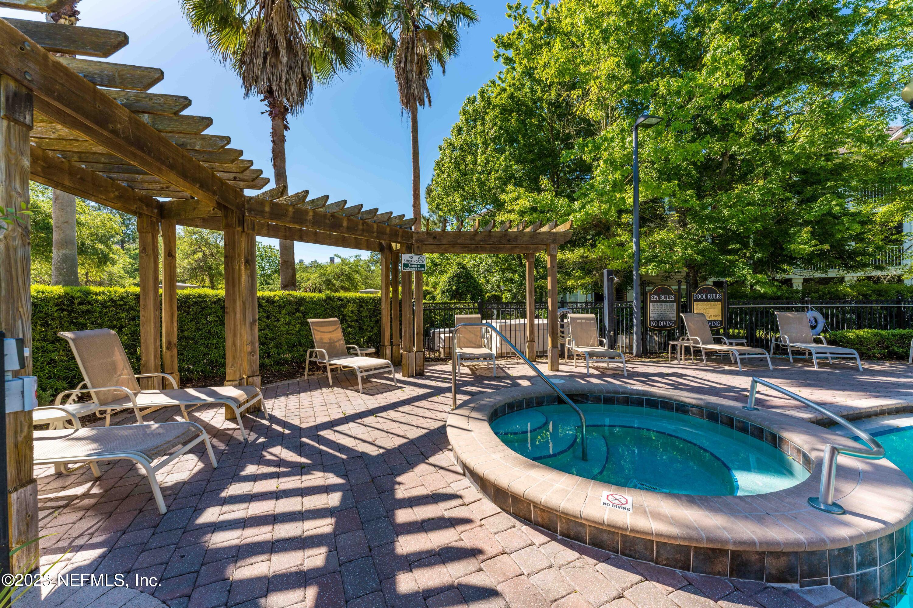 8550 Touchton Road, Unit 1136 Jacksonville, FL 32216 - Photo 44 of 53 a view of a swimming pool with chairs and table in the patio