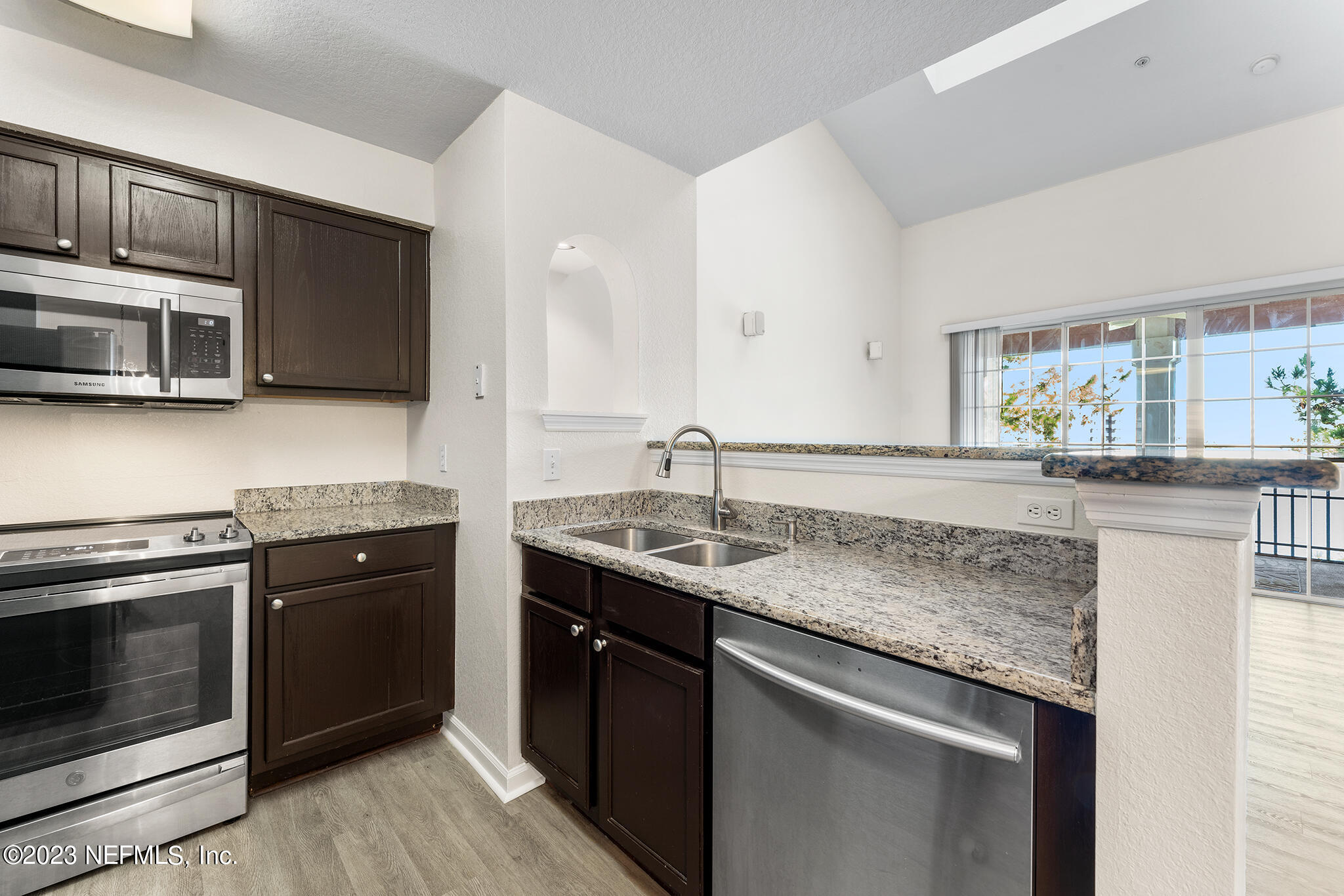 8550 Touchton Road, Unit 1136 Jacksonville, FL 32216 - Photo 8 of 53 a kitchen with stainless steel appliances granite countertop a stove microwave and sink