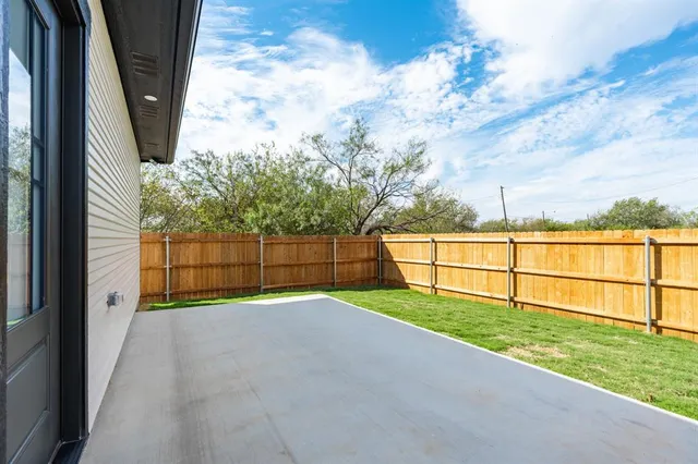 a view of a backyard with wooden fence