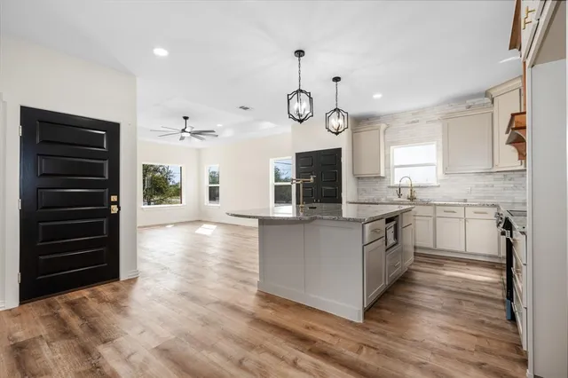 a kitchen with a refrigerator and a stove top oven