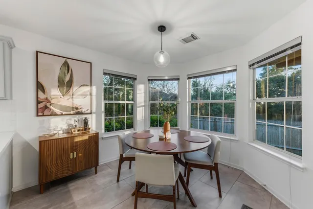 a view of a dining room with furniture large windows and wooden floor