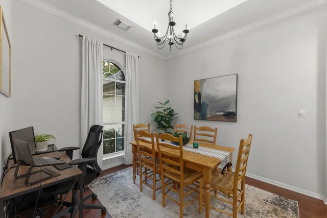 a view of a dining room with furniture and a chandelier