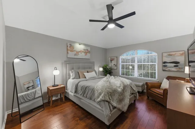 a bedroom with a bed a couch and a large window