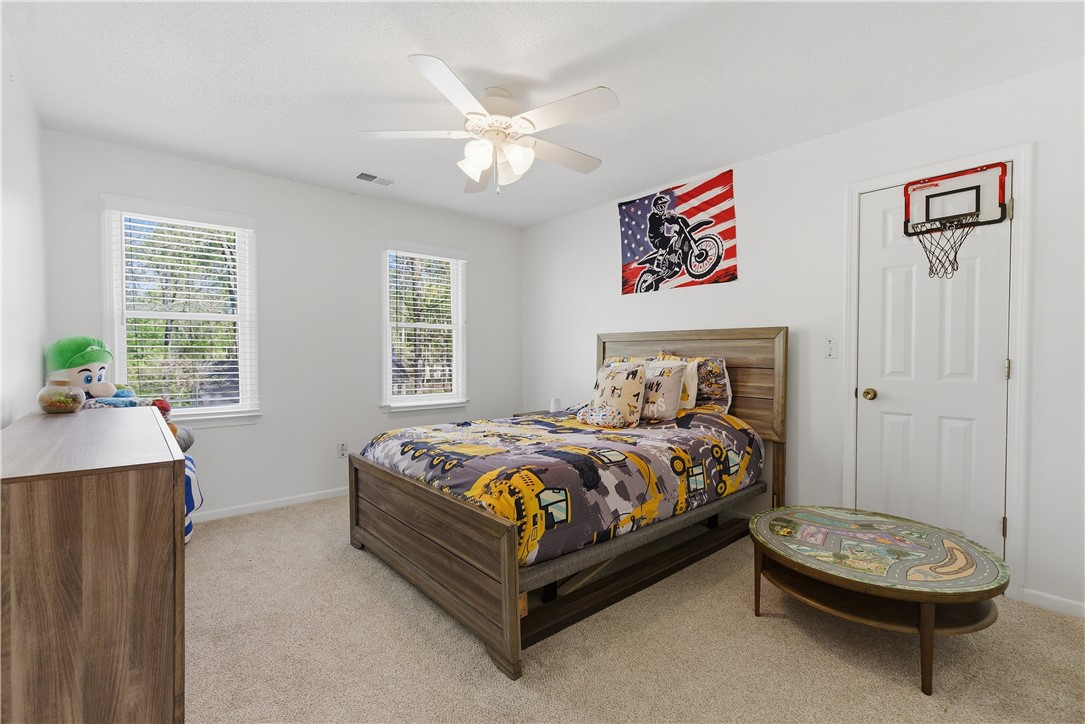 114 Halifax Road Easley, SC 29642 - Photo 23 of 32 This cozy bedroom features bright windows, soft carpeting, and a practical ceiling fan.