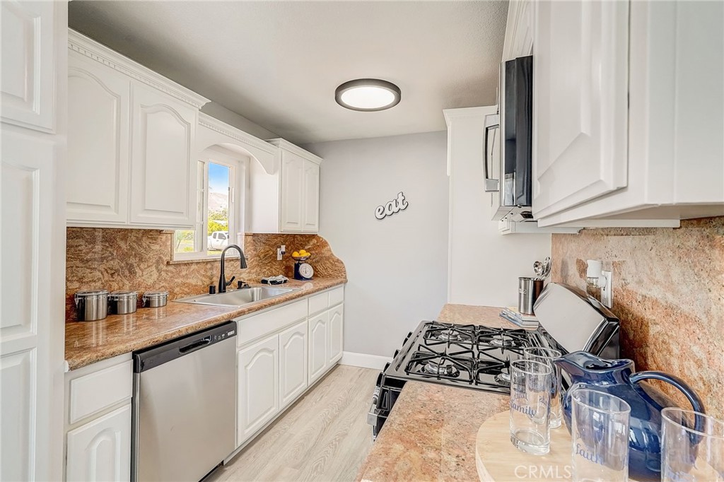 11124 Blue Jay Drive Riverside, CA 92505 - Photo 4 of 16 a kitchen with a sink a stove and cabinets
