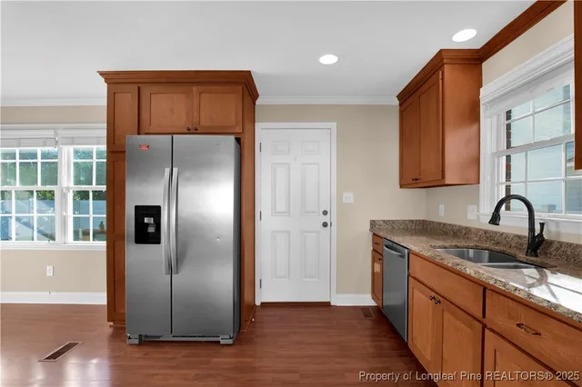 a kitchen with stainless steel appliances granite countertop a refrigerator and a sink