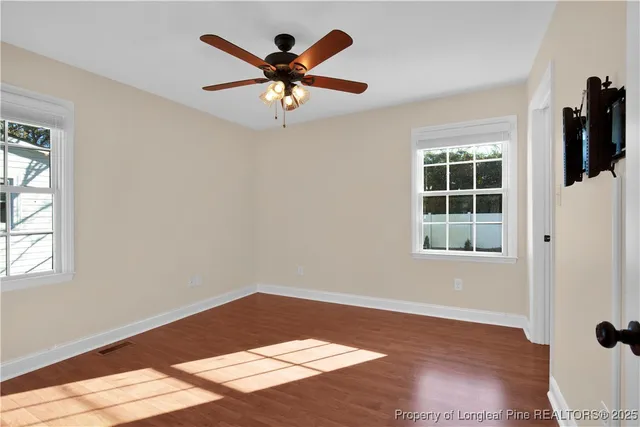 a view of a big room with wooden floor and windows