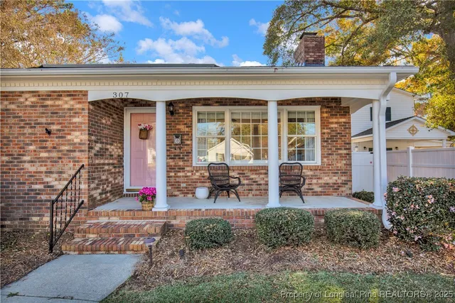 a front view of a house with sitting area and garden