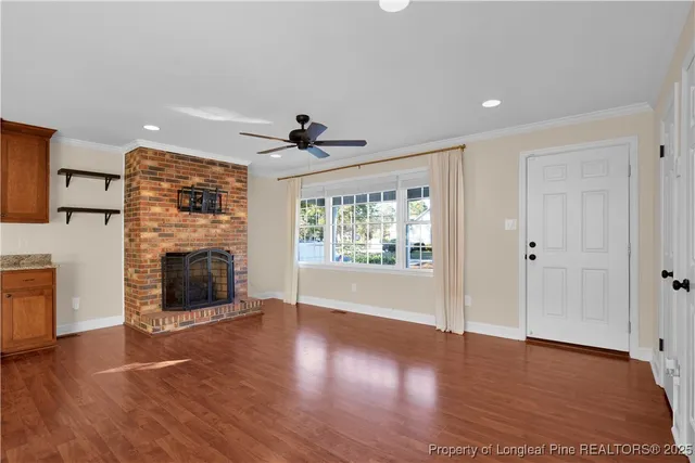 a view of a livingroom with a fireplace wooden floor and window