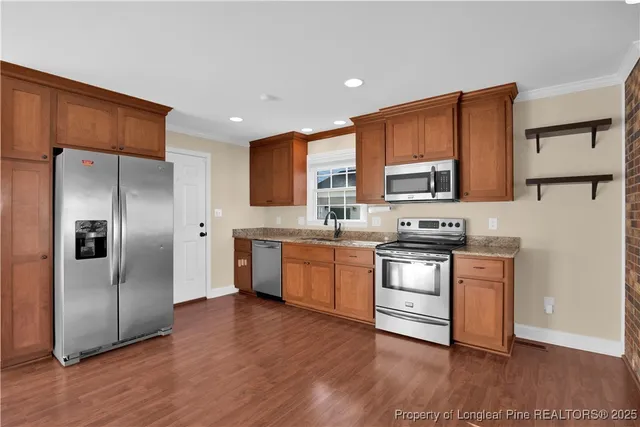 a kitchen with stainless steel appliances granite countertop a refrigerator stove and a sink