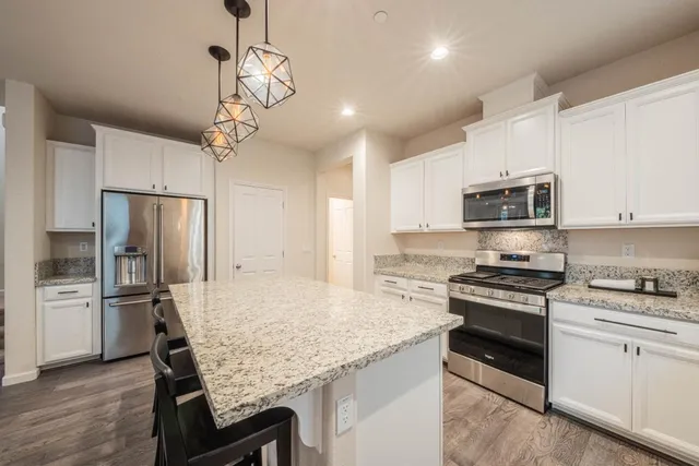 a dining hall with stainless steel appliances granite countertop furniture and fireplace