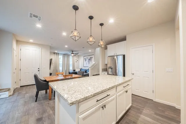 an open kitchen with a sink and dishwasher with wooden floor