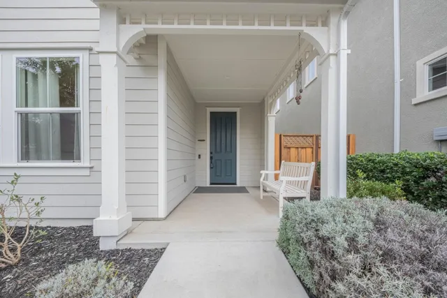 a view of a porch with a table and chairs and potted plants