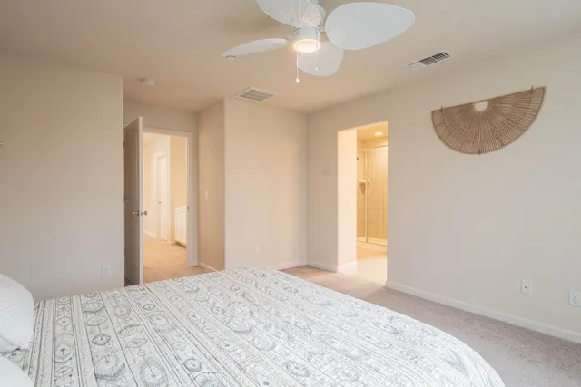 a bedroom with a large bed and a chandelier
