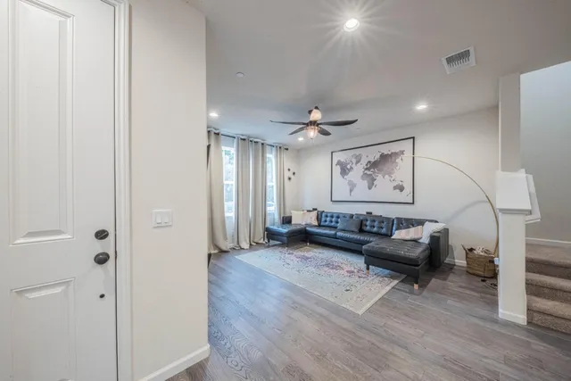 a living room with furniture and wooden floor