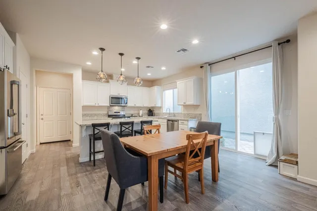 a dining room with kitchen island a table and chairs in it