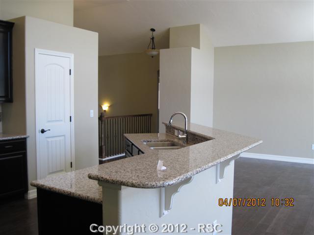 1154 Spectrum Loop Colorado Springs, CO 80921 - Photo 4 of 14 Note Iron spindels and special lighting, Pantry Slab Granite, this is photo of another finished Truman Plan