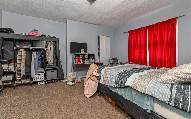 an empty room with wooden floor chandelier fan and windows