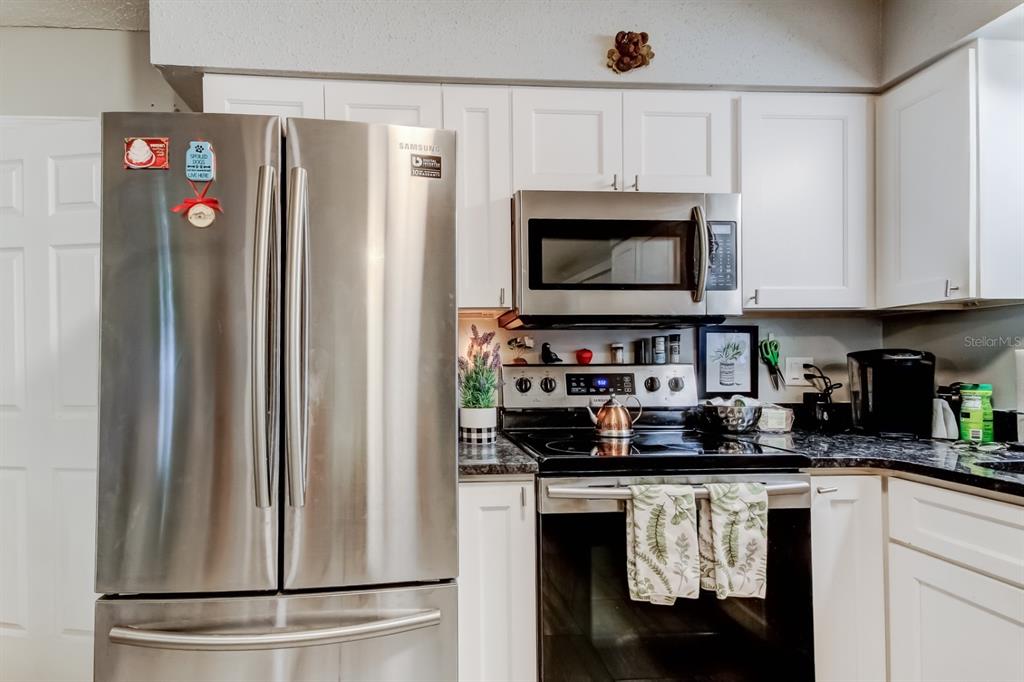 39748 Meadowood Loop Zephyrhills, FL 33542 - Photo 5 of 40 a kitchen with stainless steel appliances granite countertop a refrigerator and a microwave
